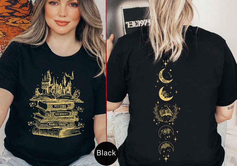 May include: Black t-shirt with a gold graphic of a stack of books with the words "Potions", "Herbology", "Magical Theory", and "Transfiguration" on the front. The back of the shirt features a gold graphic of a crescent moon with stars and a book.