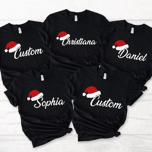 家族で揃うクリスマスサンタ帽子Tシャツ、サンタ帽子シャツにカスタム名、カスタムクリスマスTシャツ、パーソナライズされたクリスマスギフト -CC085