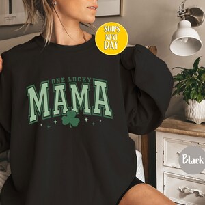 May include: Black sweatshirt with a green shamrock and the text "One Lucky Mama" in white.