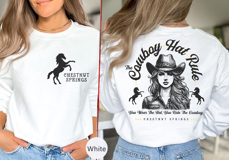 May include: White long-sleeve sweatshirt with a black silhouette of a horse and the text "CHESTNUT SPRINGS". The back of the sweatshirt features a black and white illustration of a woman wearing a cowboy hat with the text "The Cowboy Hat Rule" and "You Wear The Hat, You Ride The Cowboy" with the text "CHESTNUT SPRINGS" underneath.