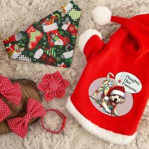 May include: A collection of Christmas-themed pet accessories. Features a red Santa-style dog hoodie, a green stocking-patterned bandana, red polka dot bows, and a red collar with a bell. The hoodie has the text "Naughty, Nice, Pawsome."