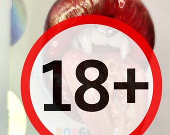 Puede incluir: Un agarre para teléfono PopSockets rojo y dorado con una señal de advertencia 18+ roja y blanca. El agarre presenta un diseño rojo, dorado y blanco con una lengua que sobresale. El fondo es una superficie blanca.