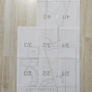 May include: A sewing pattern for a dress with instructions for cutting and sewing the fabric. The pattern includes measurements in inches and fractions of inches.