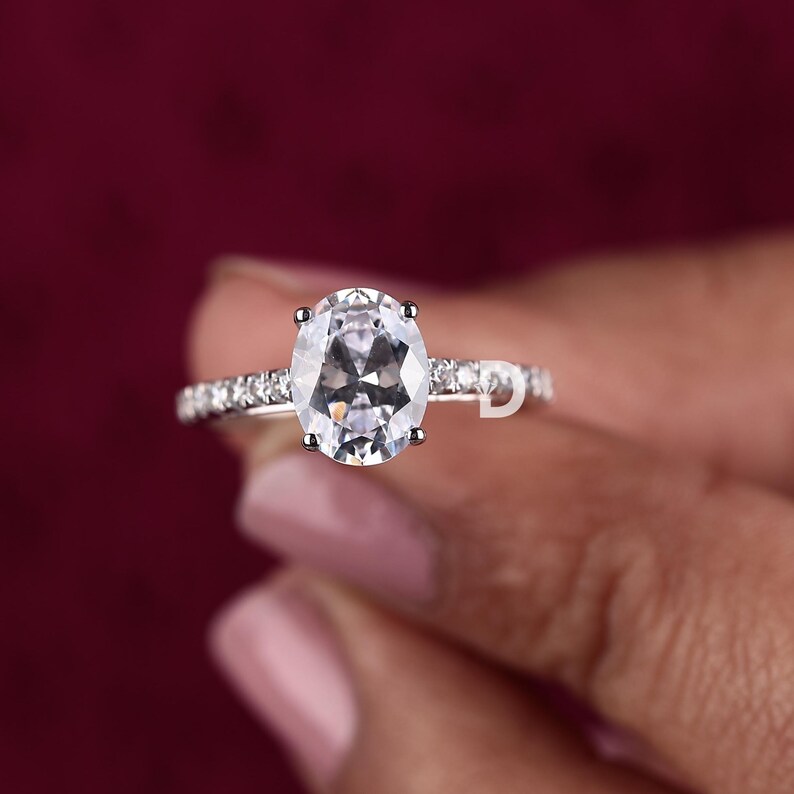 At the heart of this exquisite vintage wedding ring sits a dazzling 2.00 CT oval-cut Moissanite diamond, known for its exceptional brilliance and fire. The oval cut not only enhances the stone's radiance but also creates an elongated, graceful effect on the finger. It offers a modern twist on classic engagement rings, making it a sought-after choice for contemporary brides who appreciate vintage aesthetics.