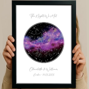 May include: Black framed print with a celestial design. The artwork showcases a purple and blue nebula with constellations in a circular design. Text includes "The Night We Met," names, and a date, creating a personalized keepsake.