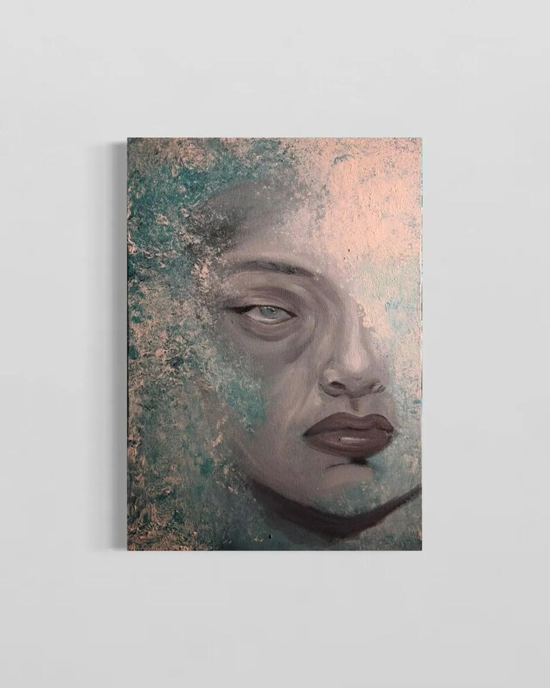 May include: A rectangular canvas painting featuring a portrait of a face rendered in shades of gray, with dark lips and eyes. The background and edges of the face are textured with blended layers of teal, turquoise, and soft peach paint.
