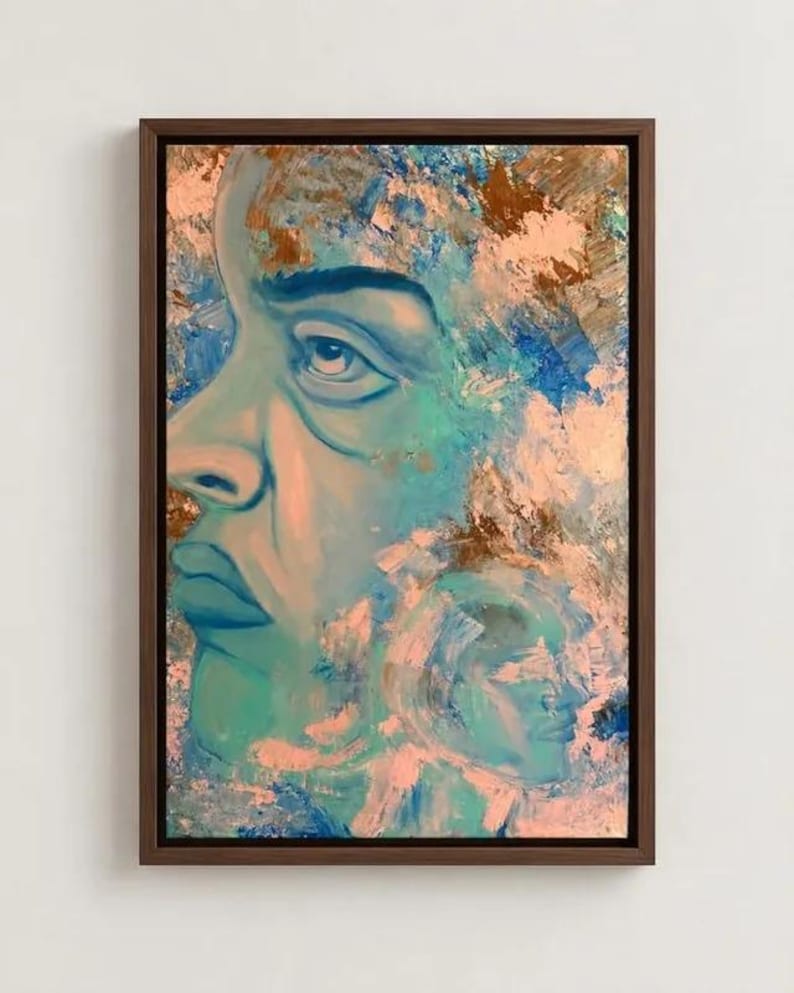 Puede incluir: Un cuadro enmarcado que muestra el perfil de un rostro en tonos azul y verde azulado, con capas de trazos texturizados en color melocot&oacute;n y oro met&aacute;lico. Un segundo perfil m&aacute;s peque&ntilde;o es visible en la esquina inferior derecha.
