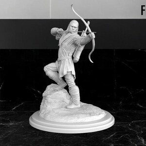 May include: A white painted figurine of a person holding a bow and arrow. The figurine is standing on a rock base and is on a white circular base.
