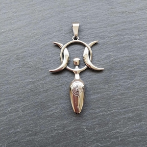 May include: Silver pendant necklace featuring a triple moon symbol with a stylised female figure in the centre. The pendant is made of stainless steel and has a polished finish.