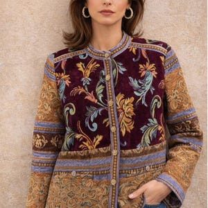 May include: A burgundy and gold floral patterned jacket with a round collar and gold buttons. The jacket has a tapestry-like design with shades of burgundy, gold, and blue. The sleeves and lower portion of the jacket feature a different, complementary pattern.
