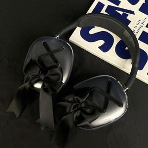 Puede incluir: Auriculares transparentes con lazos de sat&eacute;n negro en cada auricular. Los auriculares tienen una diadema negra.