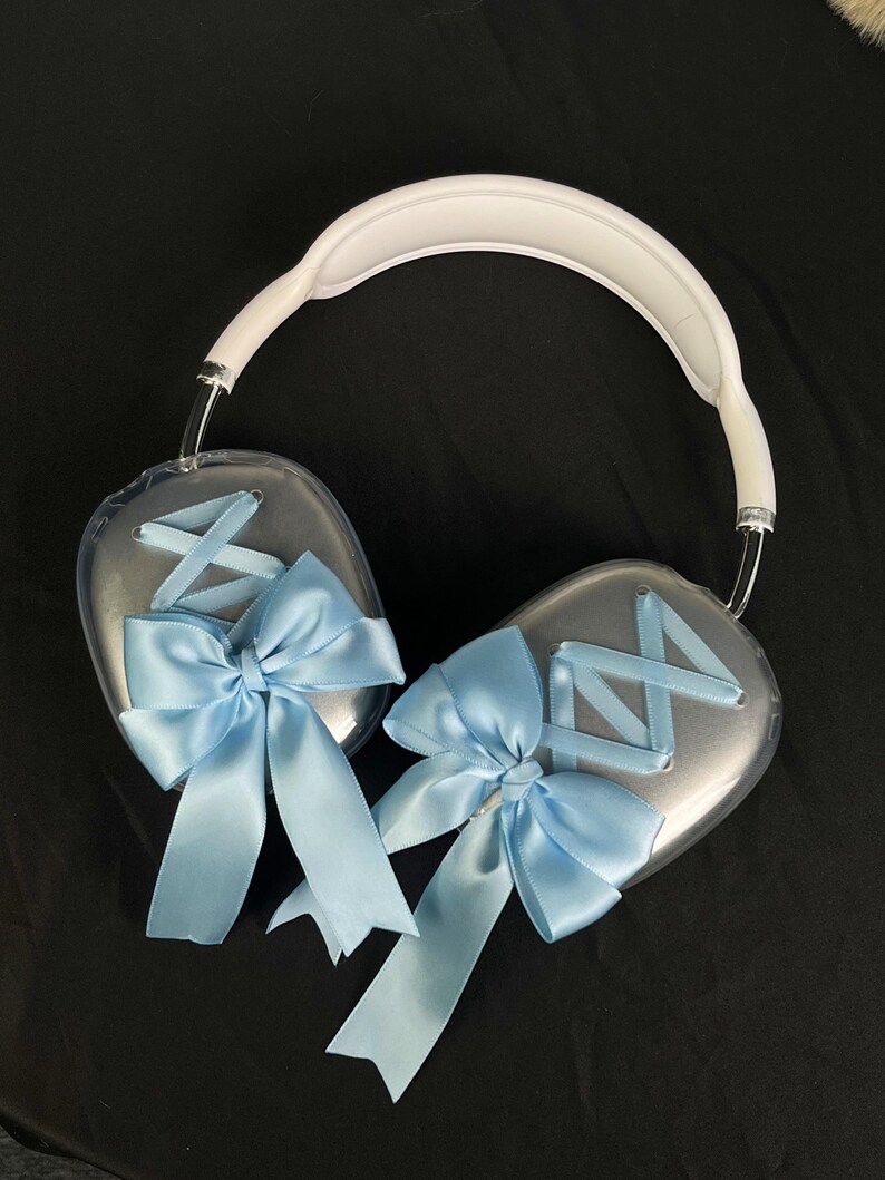 Puede incluir: Auriculares de diadema blancos con auriculares de pl&aacute;stico transparente decorados con lazos de sat&eacute;n azul.