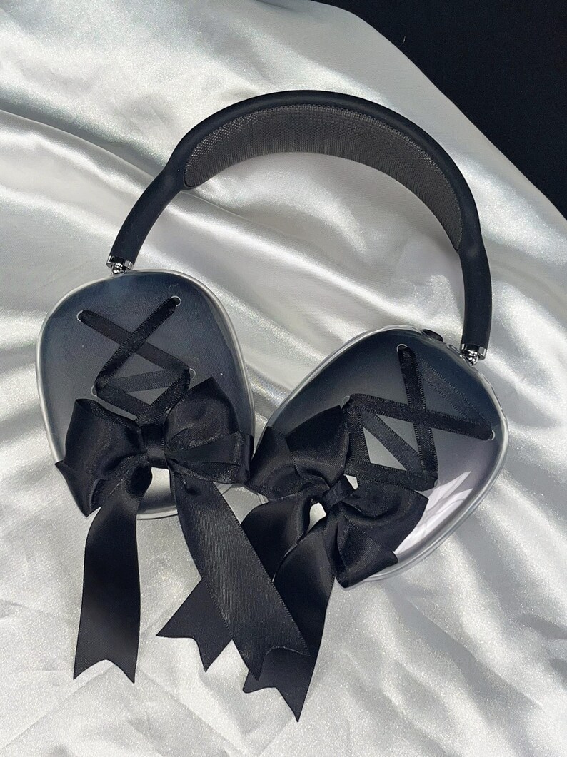Puede incluir: Auriculares transparentes con lazos negros en cada auricular. Los auriculares tienen una diadema negra.