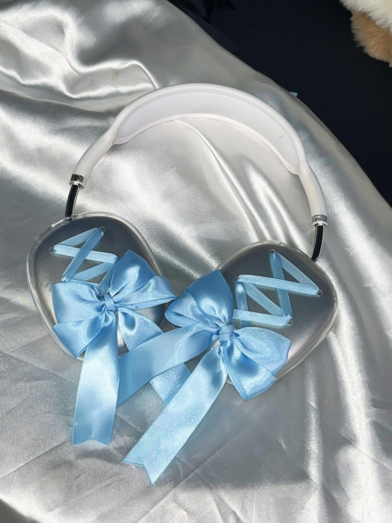 Puede incluir: Auriculares blancos con un lazo de sat&eacute;n azul claro en cada auricular. Los lazos est&aacute;n atados con un patr&oacute;n de cruz.
