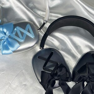 Puede incluir: Dos pares de auriculares con acabado plateado. Un par tiene un lazo de cinta azul y el otro tiene un lazo de cinta negro.