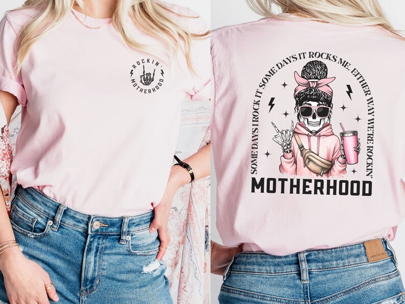 K&ouml;nnte beinhalten: Pinkes T-Shirt mit einer schwarzen Grafik eines Skeletts, das einen rosa Hoodie tr&auml;gt und ein Getr&auml;nk h&auml;lt. Der Text auf dem Shirt lautet "Some days I rock it some days it rocks me. Either way we're rockin' motherhood."