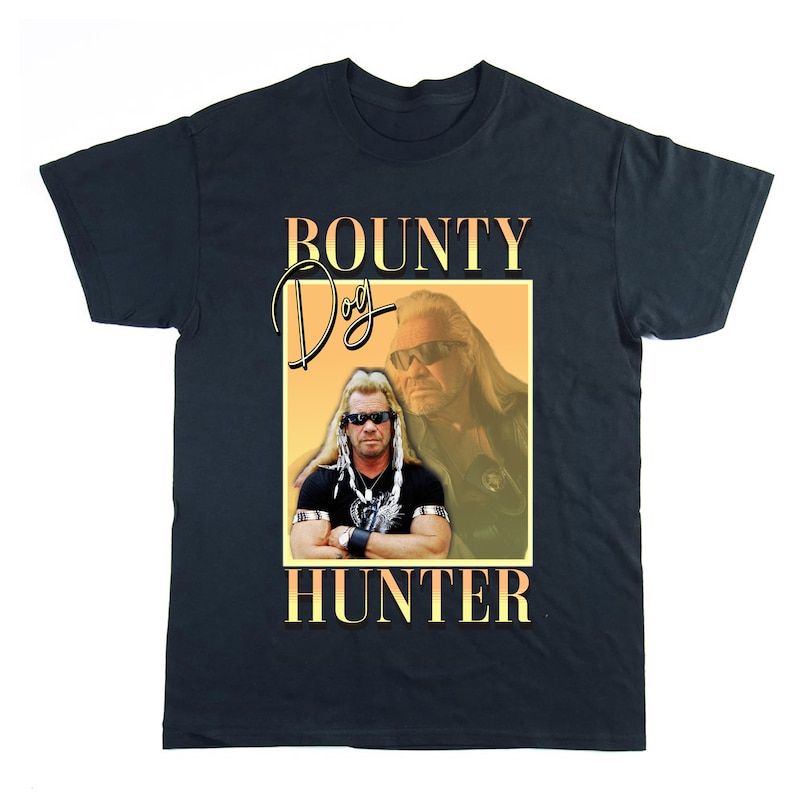 Pu&ograve; includere: Una maglietta nera con una grafica di Dog the Bounty Hunter. La grafica &egrave; in stile retr&ograve; con uno schema di colori giallo e arancione. Il testo "BOUNTY DOG HUNTER" &egrave; stampato in grandi caratteri grassetto.