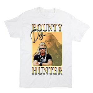 Pu&ograve; includere: Maglietta bianca con una grafica in stile retr&ograve; di Dog the Bounty Hunter. La grafica presenta uno sfondo giallo e arancione con il testo "BOUNTY DOG HUNTER" in un carattere nero grassetto.