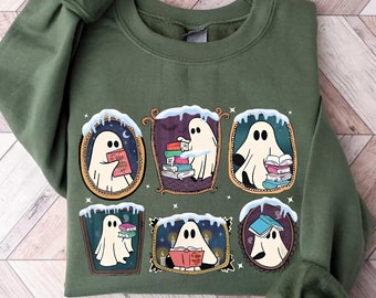 May include: A green sweatshirt with a graphic of six ghosts reading books in ornate frames. Each ghost is wearing a different expression and holding a different book. The frames are decorated with snow and icicles.