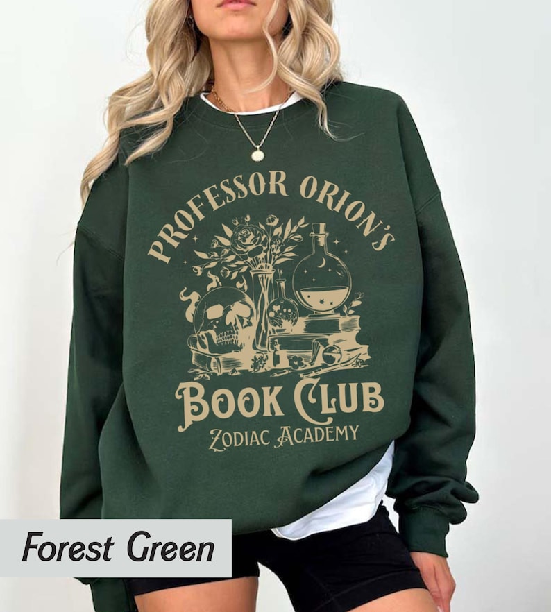 May include: Forest green sweatshirt with a graphic print of a skull, potion bottles, and books. The text reads "Professor Orion's Book Club Zodiac Academy".