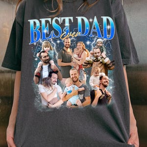 May include: A dark gray t-shirt with the text "BEST DAD Even" in blue and white letters. The shirt features a collage of photos of a man with his children.