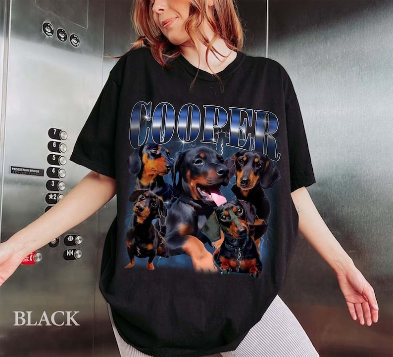 May include: Black t-shirt with a graphic of five dachshund dogs and the word "COOPER" in a blue and white gradient.
