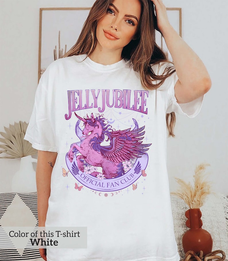 May include: White t-shirt with a purple and pink graphic of a winged unicorn with the text "Jelly Jubilee Official Fan Club".