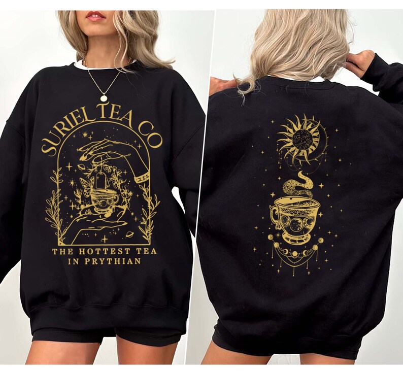 May include: Black sweatshirt with a gold design featuring a teacup, hands, and the text "Suriel Tea Co. The Hottest Tea in Prythian". The back of the sweatshirt has a gold design of a teacup with a sun and moon.