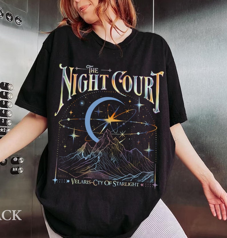 Op de afbeelding: Zwart T-shirt met een grafische print van een halve maan, sterren en bergen. De tekst "The Night Court" en "Velaris-City of Starlight" staat op het T-shirt gedrukt.