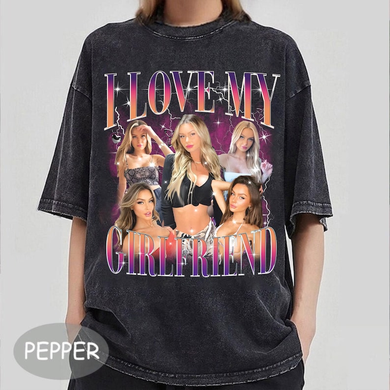 May include: Black t-shirt with a vintage-style graphic print that says "I Love My Girlfriend" with a group of women in the design. The shirt has a distressed look.