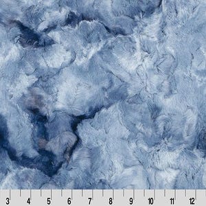 Könnte beinhalten: Nahaufnahme eines Plüschstoffs mit strukturiertem, wolkenartigem Aussehen. Der Stoff weist eine Mischung aus Blau- und Weißtönen auf und erzeugt eine weiche, flauschige Textur. Das Bild enthält ein Lineal am unteren Rand, mit Markierungen von 2.5 bis 38 cm.