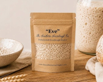 May include: A brown paper pouch containing dehydrated sourdough starter labeled "Eve" by The Southern Sourdough Co. The front features a clear window revealing the beige granular contents and the website address www.thesouthernsourdoughco.com.
