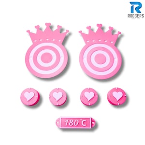 May include: A set of pink and white princess-themed coasters and a trivet. The set includes two crown-shaped coasters, four heart-shaped coasters, and a trivet with "180°C" text.