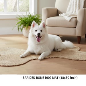 May include: A tan braided dog mat shaped like a bone, measuring 46 by 76 cm. The mat features a textured, woven surface made of natural fibres, providing a flat, durable area for a pet to rest upon while placed on a wooden floor.