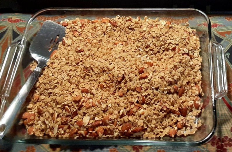 Homeade granola made with oats, honey, flax seed, maple syrup, olive oil, almonds, Himalayan salt, and optional raisins.
