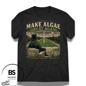 Peut inclure: Un t-shirt noir à manches courtes avec un motif représentant une silhouette en haut-de-forme devant un bassin réfléchissant vert et le Washington Monument. Le texte inclut "MAKE ALGAE GREAT AGAIN," "IN ALGAE WE TRUST," et "MIDTERMS MATTER 2024."