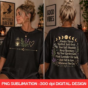 Op de afbeelding: Een zwart t-shirt met een afbeelding op de voorkant van een lantaarn, lavendeltakjes en een hart. De achterkant toont maanfasen, een zoutvaatje, lavendel en de tekst: Always throw spilled salt over your left shoulder, keep rosemary by your garden gate.