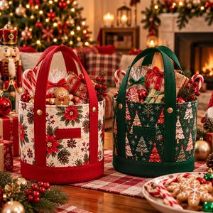 Può includere: Due cesti regalo cilindrici in tessuto con manici robusti. Il cesto a sinistra è color crema con stelle di Natale rosse e aghi di pino, con una base rossa. Il cesto a destra è verde scuro con alberi di Natale bianchi e rossi e base verde.