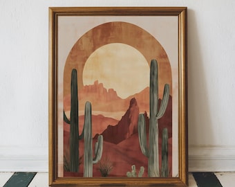 May include: Framed art print featuring a desert landscape with cacti, mountains, and a sun. The artwork is in warm tones of orange, red, and brown, with a wooden frame. The print evokes a southwestern or desert theme.