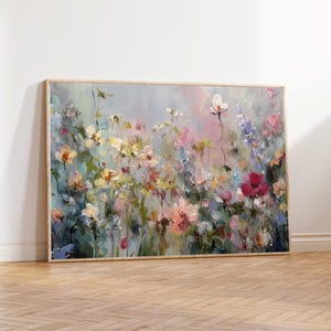 Può includere: Dipinto floreale incorniciato raffigurante un vivace campo di fiori colorati. L'opera presenta una varietà di fiori nelle tonalità del rosa, giallo, bianco e viola, su uno sfondo morbido e sfumato. Il dipinto è esposto in una cornice di legno colorata.