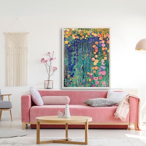 May include: A framed abstract painting of a garden with colorful flowers and green foliage. The painting is in a white frame and is hanging on a white wall.