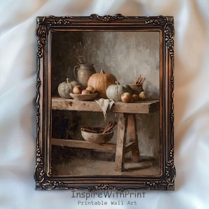 Op de afbeelding: Een ingelijste print van een stilleven met pompoenen, appels en kaneelstokjes op een houten tafel. Het kunstwerk heeft een warm kleurenpalet met bruine, oranje en groene tinten. De lijst is donkerbruin met sierlijke details. De tekst "InspireWithPrint Printable Wall Art" staat onderaan.