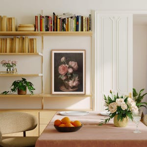 K&ouml;nnte beinhalten: Ein gerahmter Druck eines Stilllebens mit einem Strau&szlig; rosa Pfingstrosen in einer Vase. Die Blumen sind in einer Vase auf einem Tisch mit dunklem Hintergrund angeordnet. Der Druck ist in einem einfachen Holzrahmen gerahmt.