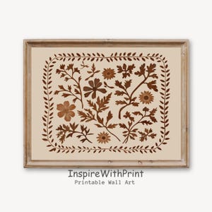 May include: A printable wall art print featuring a brown floral design with a cream background. The design is framed in a brown wood frame. The text "Inspire With Print" and "Printable Wall Art" is at the bottom of the print.