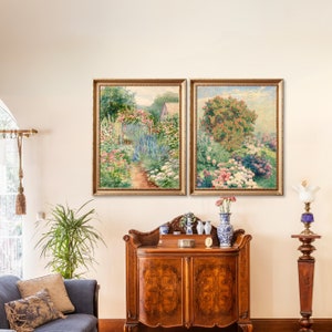May include: Two framed paintings depicting lush gardens with vibrant flowers and greenery. The paintings are hung on a white wall above a wooden cabinet with decorative accents.