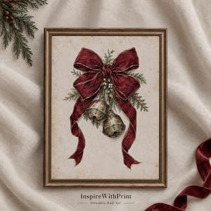 Può includere: Una stampa artistica incorniciata che presenta un'illustrazione in stile vintage di due campanelli metallici legati con un grande fiocco in velluto rosso scuro e decorati con rametti di pino verdi. Il testo "InspireWithPrint Printable Wall Art" è visibile sotto.