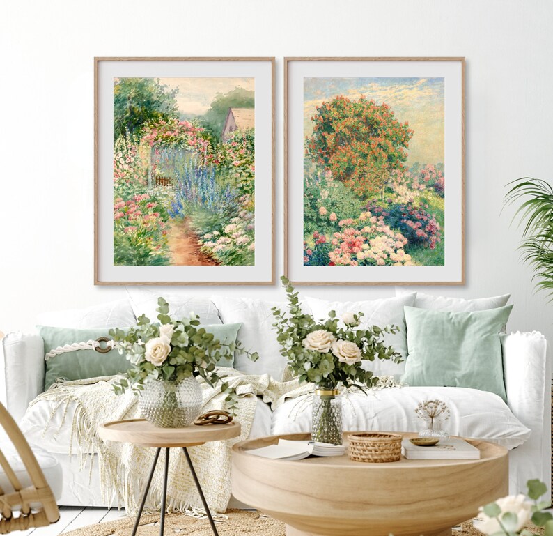 May include: Two framed watercolor paintings depicting lush gardens with vibrant flowers and greenery. The paintings are hung on a white wall above a white couch with green throw pillows.