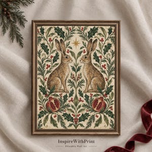 Puede incluir: Una lámina de arte enmarcada con dos liebres marrones frente a frente, rodeadas de hojas de acebo verdes, bayas rojas y dos granadas. Una estrella dorada se sitúa entre las liebres. El texto "InspireWithPrint Printable Wall Art" aparece en la parte inferior.