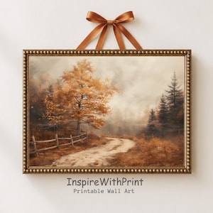 May include: A framed landscape print featuring a dirt path winding through an autumn forest with golden trees, a wooden fence, and dark pine trees under a hazy sky. The rectangular frame has a beaded edge and is hung by a brown satin ribbon.