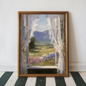 May include: A framed oil painting depicts a scenic landscape viewed through a window. The artwork showcases a vibrant meadow filled with colorful wildflowers, a mountain range, and delicate white lace curtains. The frame is a warm, golden brown.